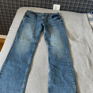 Levi's 511 blå jeans straight - Säljer ett par klassiska blå Levi's 511 jeans med rak passform. Jeansen har fem fickor, dragkedja och knapp framtill samt Levi's ikoniska läderpatch bak. Perfekta för dig som gillar en tidlös stil. Typ av jeans är straight, passar inte på mig vilket är varför jag säljer de. 10/10 helt oanvända, bara testade. Storlek 16A.