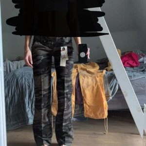 Cargobyxor med camouflage-mönster från G-LAGO - Säljer ett par cargobyxor från G-LAGO i camouflage-mönster. Byxorna har normal passform och raka ben. Perfekta för dig som vill ha en cool och avslappnad stil. Midjan är low och materialet känns mjukt och bekvämt. Helt nya