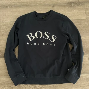 sweatshirt från Hugo Boss - En mörkblå Hugo boss tröja i storlek medium. Väldigt fint skick, som ny. Köpt på Hugo boss för ett par år sedan. Nypris 1500