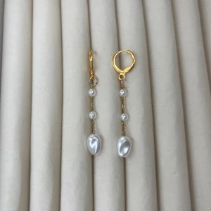 Guldpläterade örhängen med pärlor - Säljer ett par eleganta örhängen med guldfärgade ringar och hängande vita pärlor i olika storlekar. Perfekta för att ge en lyxig touch till din stil. Enkla att bära och passar till många tillfällen.