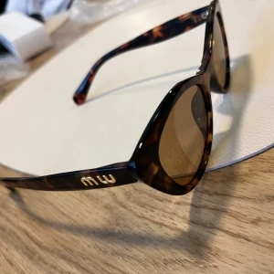 Nya bruna cat eye-solglasögon - Säljer mina sköldpaddsmönstrade solglasögon. Bågarna är i plast och har guldfärgade emlem på sidorna. Glasen är bruna och ger en vintagekänsla. Nya! Säljes eftersom jag inte fått användning för dem.