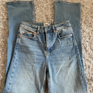 Ljusblå jeansbyxor med slits från 157 - Säljer ett par ljusblå jeansbyxor från Lager 157 i storlek XS. Byxorna har klassisk femficksdesign, raka ben och en snygg slits nertill på benen. Perfekta för dig som gillar en enkel och stilren look. Aldrig använda men utan prislapp. 
