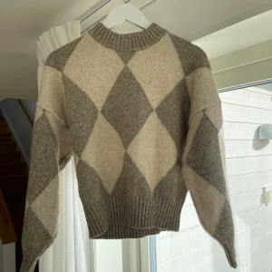 Grå och beige stickad tröja med rutor - Säljer denna beige gråa stickade tröjan. Fin passform och tajtare i midjan.