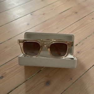 solglasögon från Chimi - Snygga solglasögon från Chimi i modellen 04.2 Ecru. De har en fyrkantig form och är tillverkade i transparent beige plast med bruna tonade glas. Kommer med originalfodral och tygpåse.