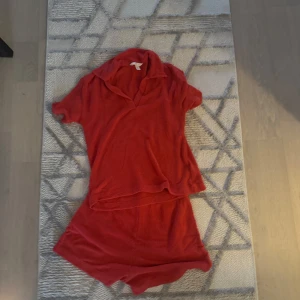 Röda shorts och tröja  i frotté set  - Mysiga röda shorts i mjuk frotté med avslappnad passform och elastisk midja. Perfekta för sommardagar eller som loungewear. Matchar toppen för en komplett look.