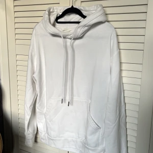 Vit hoodie - Säljer en klassisk vit hoodie från H&M med huva och dragsko. Använd ett fåtal gånger och det finns inget slitage. Perfekt för en avslappnad stil och enkel att matcha med det mesta.