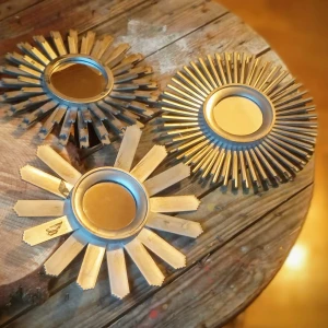 Solformade speglar i silvrig färg  - Unika speglar i form av små solar med spegel i mitten och strålande detaljer runtom. Tillverkade i silverfärgat material som ger en cool och iögonfallande design. Perfekta för att liva upp något tråkigt och omodernt rum eller vrå. Obs! Den ena saknar en solstråle. 