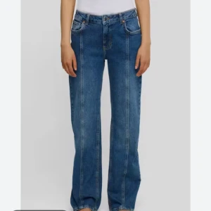 Blå wide jeans med hög midja - Säljer ett par blå jeans med bred passform och hög midja. Jeansen har raka ben, klassiska fickor och markerade sömmar framtill. Midjemått är W28 och längd 32. Perfekta för en avslappnad och trendig look.