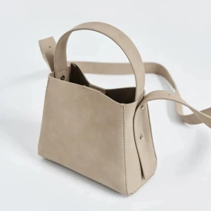 Beige liten väska från Gina  - Pu mini bag från Gina tricot i beige, bra skick. Lite slitage på handtaget bara 