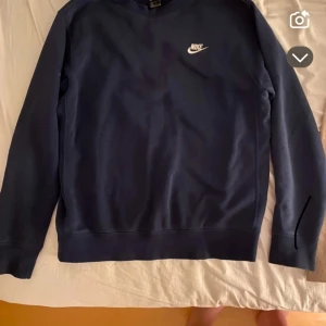 Mörkblå sweatshirt från Nike - Säljer en stilren mörkblå sweatshirt från Nike med klassisk logga på bröstet. Tröjan har rund halsringning och långa ärmar. Perfekt för en sportig och avslappnad look.