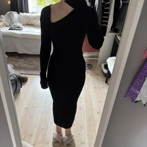 Svart  långklänning - Säljer en svart, figurnära långklänning med oneshoulder-design och lång ärm. 