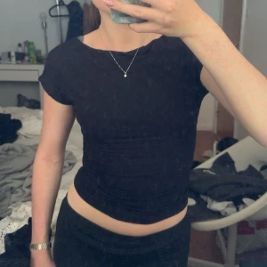 Svart och röd croppad topp med öppen rygg - Två croppade toppar i svart och rött med korta ärmar och en snygg öppen rygg. Toppens passform är tight och den har en enkel, stilren look utan mönster eller extra detaljer. Perfekt för dig som gillar minimalistisk stil och vill visa lite rygg. Säljes i pack, tillsammans 