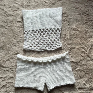 Vit virkat coverup set - Virkat vit coverup set med armlös topp och lågmidjade shorts, perfekt att ha utanpå bikinin en varm sommardag!
