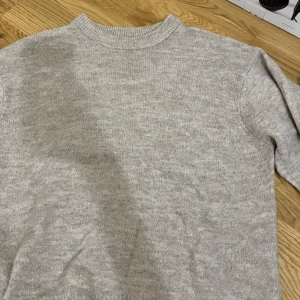 Beige stickad tröja  - Mysig beige stickad tröja från Lager i storlek XS. Tröjan har en klassisk rund halsringning och långa ärmar med ribbade muddar. Perfekt nu inför hösten och vintern!                                               OBS! Köparen står för frakten!