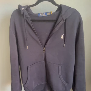Mörkblå hoodie från Polo Ralph Lauren - Tja jag säljer min Ralph lauren hoodie! Den är lite sönder på den vänstra armen men det lägger man inte märke på. Hör av er vid minsta lilla 