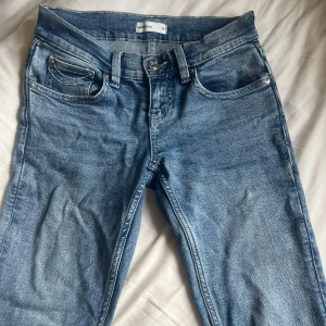 Blå bootcut jeans från Perfect Jeans - Snygga blå jeans från Perfect Jeans med bootcut-modell och låg midja. Jeansen har klassiska fem fickor, coola kontrastsömmar på bakfickorna och en bekväm passform. Perfekta till sneakers eller boots.
