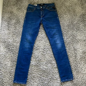 Blå skinny jeans från Replay W30 L32 - Säljer ett par blå skinny jeans från Replay i klassisk femficksmodell. Jeansen har snygga slitningar och smal passform hela vägen ner. Perfekta för dig som gillar en tajt look.