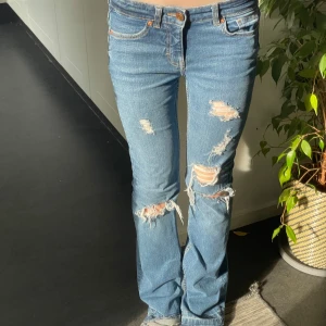 Bootcut jeans - Säljer ett par bootcut jeans med slitningar. Midjemåttet rakt över: 35cm. Innebenslängden: 79cm. Midjehöjden: 20cm💓