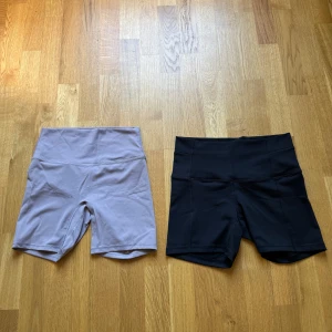 Två par höga cykelshorts - Två par cykelshorts med hög midja, ett par i ljuslila och ett par i svart. Båda är stretchiga och har en tight passform, perfekta för träning eller chill. Snygg minimalistisk design utan synliga loggor eller detaljer. 80kr/styck