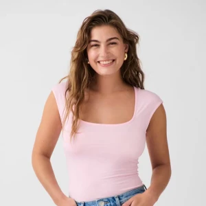 Ljusrosa ärmlös linnetopp - Supersöt ljusrosa linnetopp med fyrkantig ringning och tight passform. Perfekt att matcha med jeans eller kjol för en fräsch look. Mjuk och stretchig bomullskänsla som sitter skönt hela dagen.