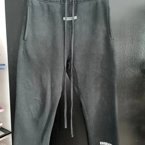Svarta Essentials Fear of God mjukisbyxor - Riktigt sköna mjukisbyxor från Essentials. Dem är svarta och storleken är M men skulle kunna funka för någon som bär S. Hör av er om ni har frågor eller funderingar.