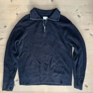 Mörkblå stickad half zip från East West - Snygg mörkblå stickad tröja från East West med ribbad struktur och half zip-dragkedja vid kragen. Perfekt för lager-på-lager och chill stil. Långärmad och med en klassisk, lite loose passform. Nypris 800. Pris kan diskuteras vid snabb affär.