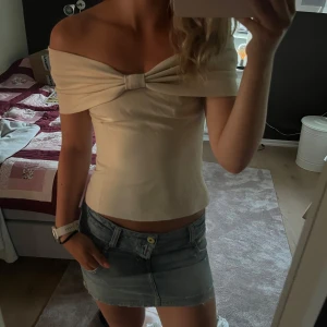 Cremefärgad offshoulder topp - Så snygg offshoulder topp från NAKD med rosettdetalj🤍🤍aldrig använd endast testad och prislappen är kvar! Originalpriset är 550kr