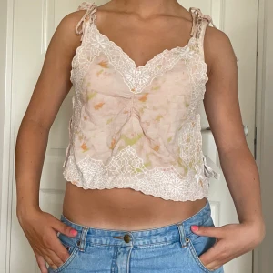 Gullig linnetopp från Zara!! - Superfin ljusrosa linnetopp från Zara med broderade spetsdetaljer och knytband på axlarna. Toppen har en croppad passform, v-ringning och subtila inslag av gult och grönt i tyget. Perfekt för en somrig look med jeans eller kjol. Skriv om du vill se fler bilder eller har andra frågor 🩷 Nypris 350kr