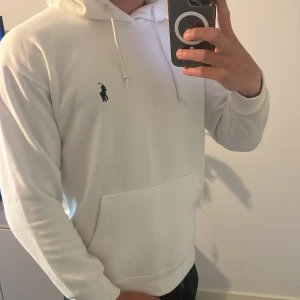 Vit hoodie från Ralph Lauren - Säljer nu min oanvända hoodie från Ralph lauren i storlek M. Prislappen finns kvar och sitter på. Jag är 180cm och den sitter bra på mig .