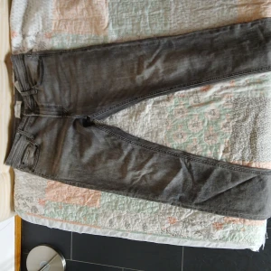 Grå jeans slim fit - Säljer ett par grå jeans med klassisk femficksdesign och smal passform. Jeansen har en mörk tvätt och subtila slitningar för en cool look. Perfekta till sneakers eller boots och funkar året runt. Passar m/s