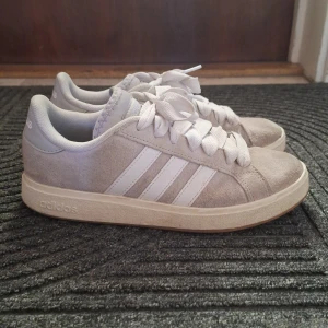 Grå/Beige adidas sneakers i mocka - Adidas skor i bra skick. Storlek 38, använda några gånger men de är fortfarande bra och man kan ha på sig de länge. 