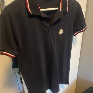Svart Moncler pikétröja med rödvit kant - Moncler polo marin blå storlek s sitter lite större 