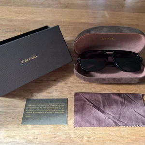 Tom Ford solglasögon - Snygga svarta solglasögon från Tom Ford med klassisk rektangulär form. Kommer med originalfodral, putsduk och certifikat. Priset är diskuterbart vid snabb och smidig affär. Skick 9/10