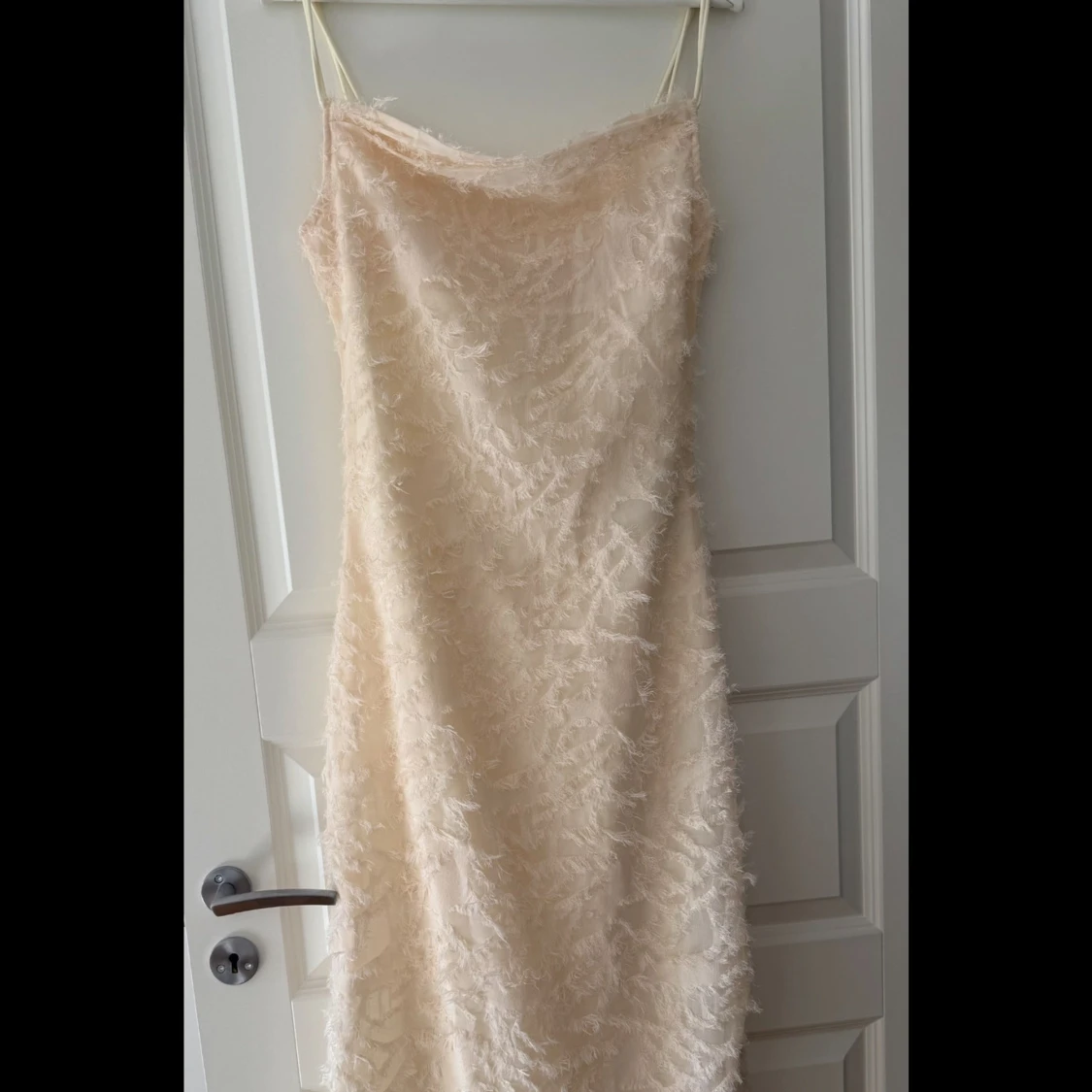 Cremefärgad långklänning med fjäderdetaljer från Vila - 3