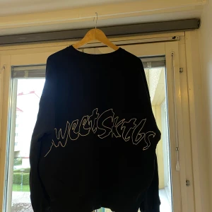 Svart sweatshirt från Sweet SKTBS - Snygg sweet sktbs tjocktröja i svart och tjockt tyg. Mycket bra kvalitet. Tröjan är i väldigt fint skick inga hål eller fläckar. Har knappt använt tröjan därför säljer jag den. Tror jag köpte den för 800 från junkyard. 