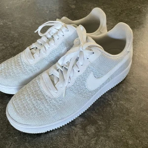 Vita Nike Air Force sneakers - Säljer ett par klassiska vita Nike Air Force sneakers med snörning och rund tå. Skorna är helt nya, använd 1 gång bara!!! Köpt för ungefär 1000, så säljer för riktigt bra pris.