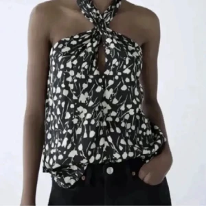Svartvit halterneck blus med knyt - Snygg svartvit blus med abstrakt mönster och halterneck med knyt i nacken. Sparsamt använt