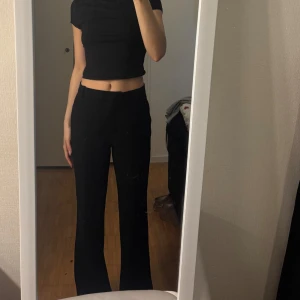 Svarta vida byxor - Säljer ett par svarta byxor med hög midja och vida ben. Byxorna har en klassisk look och passar perfekt till både enkla och mer uppklädda outfits. Sköna och stilrena, perfekta att matcha med crop top eller skjorta.