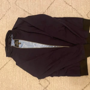 Mörkblå bomberjacka från Scotch & Soda - Säljer en stilren mörkblå bomberjacka från Scotch & Soda. Jackan har dragkedja framtill, ribbade muddar vid ärmslut och midja samt ljusblått foder. Perfekt för dig som vill ha en klassisk och snygg jacka till vardags.