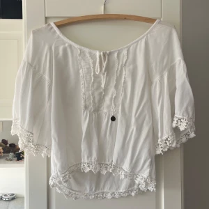Supersöt topp - Säljer denna super söta vita toppen med spets detaljer och trekvarts ärm💕 Passar perfekt till sommaren eller våren💕Står ingen storlek i den med skulle tro att den är XS/S💕