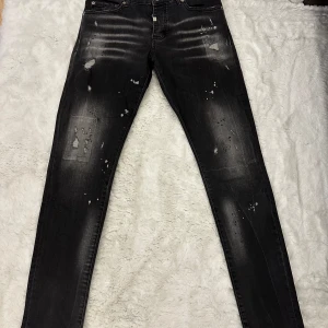 Svarta skinny jeans från Horspist - Säljer ett par svarta skinny jeans från Horspist med slitningar och blekta detaljer. Jeansen har klassisk femficksdesign och knappgylf. Perfekta för dig som gillar en edgy stil.