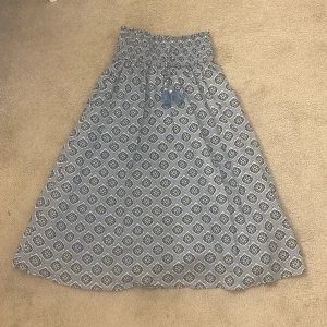 Blåmönstrad långkjol från Gina Tricot - Säljer en blå långkjol från Gina Tricot med vitt och mörkblått mönster. Kjolen har tofsar framtill, som på en av de har pärlorna gått sönder. Finns inte längre i buktik eller online. Priset kan diskuteras💕