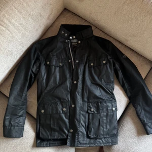 Barbour International wax jacka - Säljer en svart Barbour International wax jacket i nyskick. Köpte den förra veckan och har enbart använd ute vid två tillfällen. Säljer den eftersom den inte riktigt passar min klädstil. Perfekt för höst och vår.