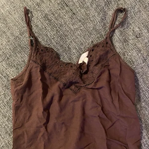 Brun linnetopp med spetsdetaljer - Söt brun linnetopp med tunna axelband och fina spetsdetaljer. 🤎