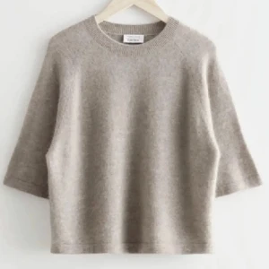 Beige stickad tröja från & Other Stories - Mysig beige stickad tröja från & Other Stories. Perfekt för höst och vår med sina trekvartsärmar och mjuka material. Enkel och stilren design som passar till det mesta. Ett måste i garderoben för en avslappnad look! Skriv för egna bilder