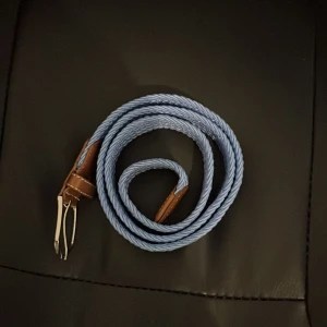 Blått flätat bälte med bruna skinn-detaljer - Ett unikt ljusblått bälte som passar bra på jeans eller chinos och är 90 cm