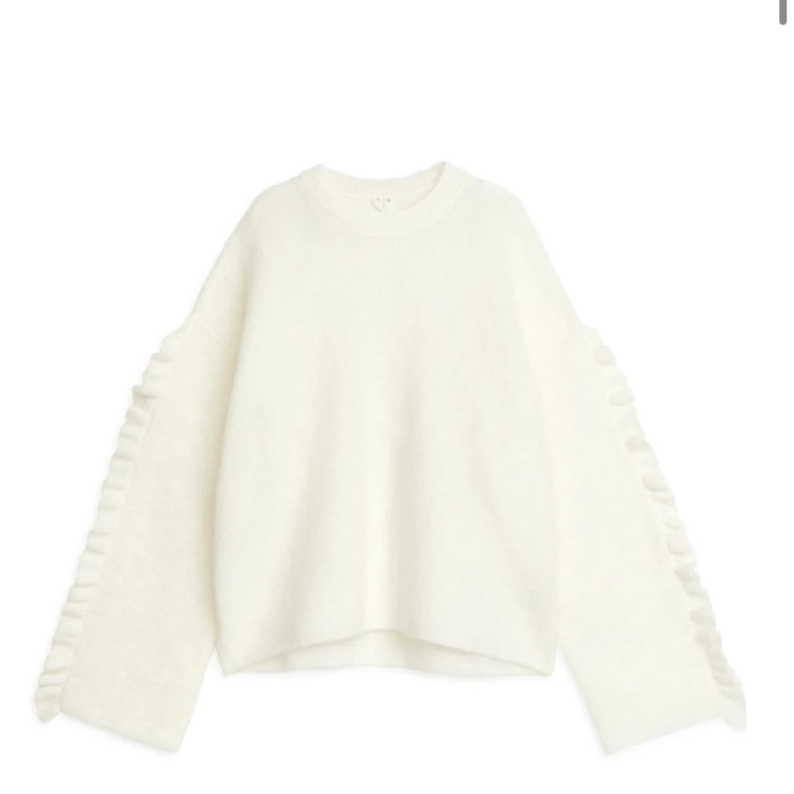 Vit stickad tröja med volangdetaljer