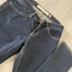 Mörkblå jeansbyxor från Peak Performance - Säljer ett par klassiska mörkblå jeans från Peak Performance med kontrastsömmar och femficksmodell. Byxorna har normal passform och är tillverkade i slitstarkt denim. Perfekta för dig som gillar stilrena och tidlösa jeans🥰💗