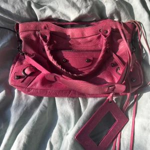 Rosa handväska från Balenciaga - Väska från Balenciaga i en unik färg! Perfekt storlek och har både axelband och spegel, vilket är ovanligt. Har slitningar i lädret på vissa ställen, men inget som stör helhetsbilden💗🩷