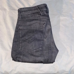 Svarta jeansbyxor från Replay - Säljer ett par svarta Replay jeans med klassisk femficksdesign och diskreta sömmar. Byxorna har slim-fit passform och raka ben, perfekt för en stilren look. Materialet är mjukt och stretchigt för extra komfort. 28w, 30l